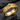 Detailed view of the 925 sterling silver hourglass ring with gold vermeil finish resting on dark stone