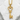 Close-up of the radiant gold vermeil heart key pendant resting gracefully on a textured white stone surface