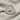 Orixa Oxossi Ring, polished silver, front view on fabric