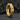 Close-up of a chunky gold industrial hoop earring resting on a dark textured stone showcasing the craftsmanship