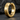 Macro view of gold vermeil hoop earring resting on dark stone showcasing architectural metalwork