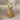 Conch spiral shell earring, gold vermeil, front view on neutral fabric