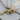 Detailed view of the stylized submachine gun pendant resting on a natural wood slice highlighting engravings