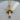 Close-up flat lay of the regal crown cross pendant showing the detailed 3D gold vermeil craftsmanship on a textured surface.