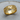 Detailed close-up of the handcrafted grapevine band ring resting on a textured wooden slice highlighting the gold