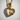 Close-up macro view of the gold heart skull pendant highlighting the detailed bone structure and sparkling stone settings