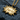 Detailed view of the jagged star-burst manga speech bubble pendant resting on dark textured stone alongside rustic twigs