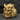 Close-up of gold vermeil Oni demon mask ring with intricate samurai helmet details on a dark stone background.
