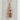Ramune Soda Bottle Pendant, rose gold, front view against light stone