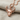 Hittite Bull Pendant, rose plated silver, front view on fabric