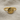 Close-up of the two-tone Hittite sun ring resting on textured linen fabric, detailing the bull horns and radiating rays