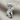 Microphone Fist Pendant, polished silver, angled view on linen fabric