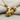 Grip Barbell Pendant, gold vermeil, angled view on fabric
