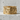 Close-up of a gold vermeil howling wolf ring with pine trees and mountain relief on a concrete background