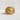 Close-up of gold Templar cross shield ring with intricate scrollwork resting on textured stone surface