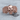 Spread Wing Skull Ring, rose gold, front view on wood surface