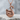 Floating Swan Pendant, rose gold, angled view on stone