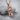 Cracked Skull Bullet Pendant, rose gold, angled view on textured stone