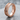 Arrow Spinner Ring, rose gold, angled view on stone surface