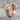 Flared Gothic Cross Earring, rose gold plated, angled product photo on stone