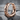 Forge hammered hoop earring, rose gold, product photo on stone