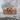 Studded Skull Ring, rose gold, front view on stone surface