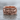 Intertwined Skull Ring, rose gold, front view on stone surface