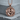 Twin Horses Pendant, rose gold, front view on concrete block
