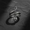 High-angle view of 925 sterling silver snake ring showing coiled design and textured scales on dark stone background