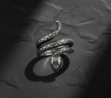 High-angle view of 925 sterling silver snake ring showing coiled design and textured scales on dark stone background