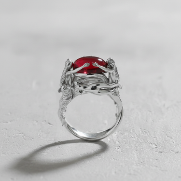 925 sterling silver nymph ring featuring three female figures holding a red cabochon stone