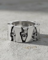 925 sterling silver skull gear ring featuring alternating skull faces and polished panels on stone surface