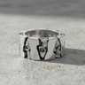 925 sterling silver skull gear ring featuring alternating skull faces and polished panels on stone surface