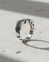 Close up of segmented armor style silver ring for men with brushed metal texture and sparkling accents