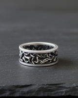 Front view of 925 sterling silver tree branch ring with intricate root design on dark stone background