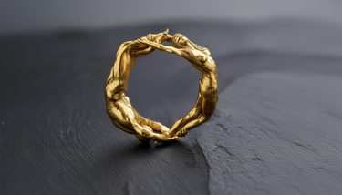 Gold vermeil lovers ring featuring male and female figures forming a circle on dark textured background