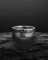 925 sterling silver raw texture ring with rugged fissure design and dark stones displayed on black charcoal background
