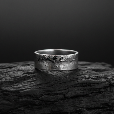 Side view of 925 sterling silver ring featuring molten texture and black crystals on dark wood