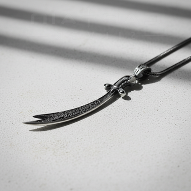 Angled view of silver Zulfiqar pendant showing double-pointed blade and intricate handle detail