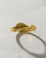 14k gold vermeil leaf ring with intricate vein details on grey stone background