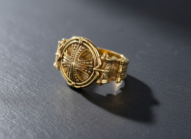 Gold vermeil silver cross ring with an intricate Byzantine design and granulated cross, shown on a dark textured surface.