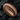 Rose gold plated ribbed band ring highlighting the deep geometric grooves resting on dark textured stone