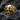 Front view of gold vermeil ornate skull ring resting on dark textured stone highlighting the memento mori design