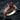 Detailed view of the elegant garnet promise ring showcasing the red gemstone resting on a dark stone surface