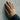 Lifestyle shot of the handcrafted 925 silver fist bump ring worn on a hand touching a concrete wall