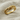Close-up detail of a gold gem eye snake ring resting softly on textured linen showing fine craftsmanship