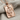 Queen of diamonds pendant, rose gold plated, angled view on fabric