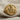 Close-up of gold vermeil Saint Mark signet ring resting on textured fabric highlighting the detailed gospel book