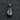 Close-up detail of the oxidized silver boxing glove pendant resting on a dark textured background highlighting details