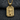 Close-up of rectangular dragon pendant in gold vermeil with sculpted central orb resting on dark fabric